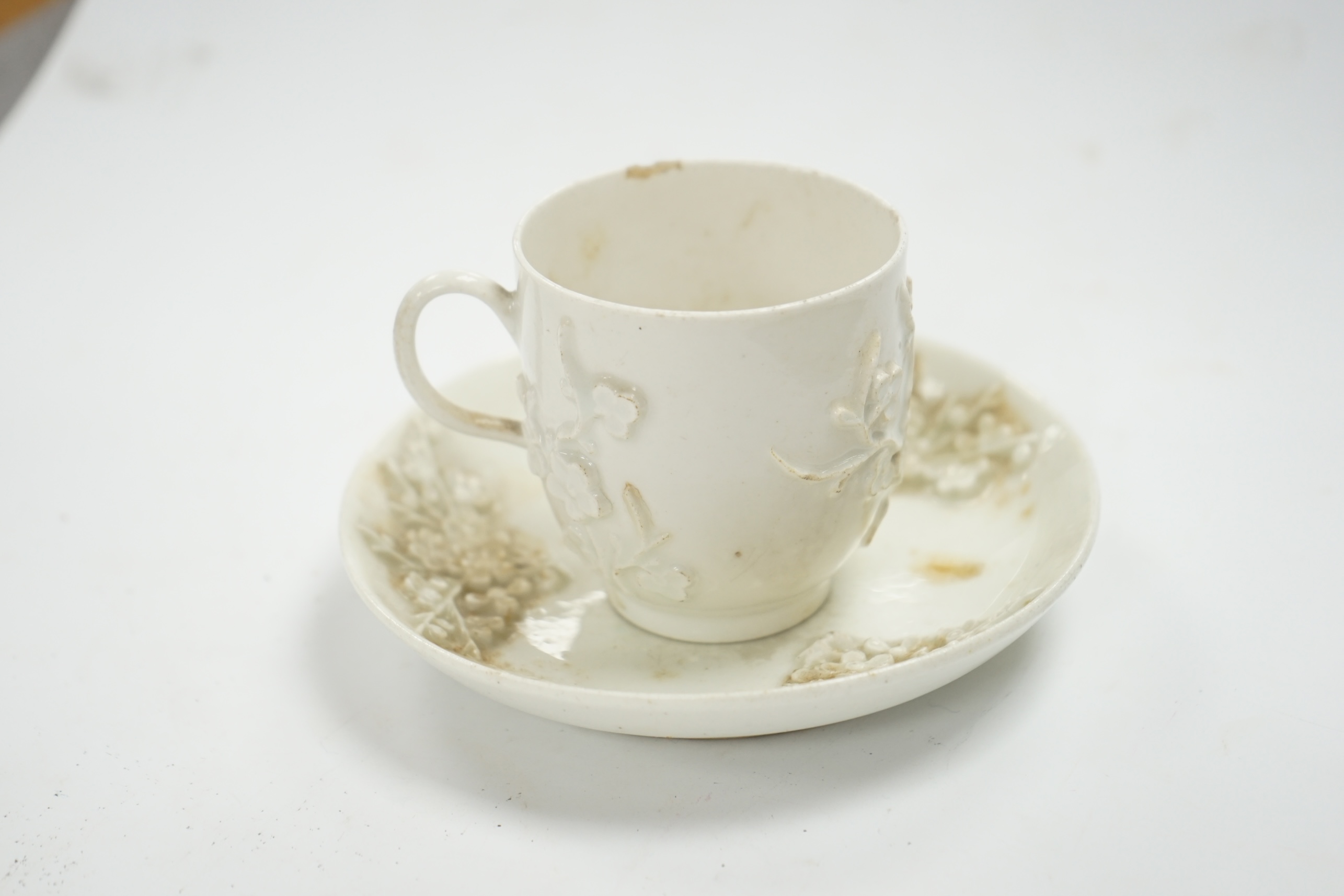 A Bow prunus sprigged coffee cup and saucer, c.1760, saucer 11.5cm diameter, cup 6cm high. Condition - cup has a chip to the rim and both saucer and cup interior have wear to glazing